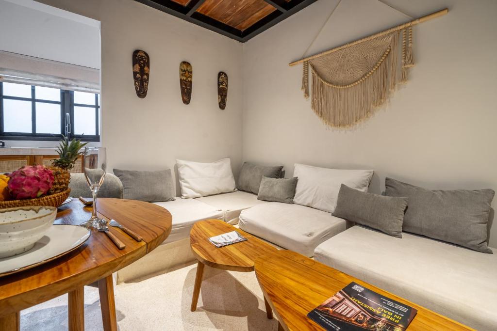 a living room with a couch and a table at Reconnect in Ubud - Peaceful Living at Sarang Apartments 1 in Ubud
