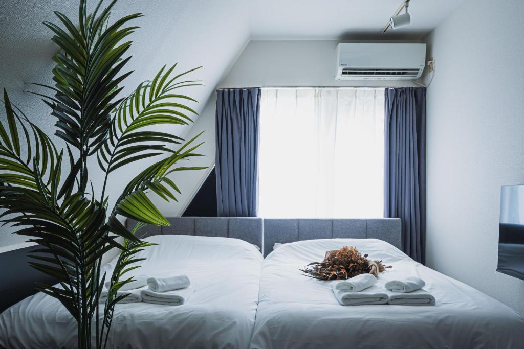 a bedroom with a bed with a plant next to a window at SLL Urban Suites Akasaka in Tokyo