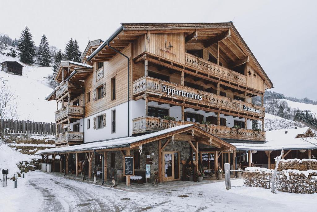 a large wooden building in the snow at Appartements Liebe Heimat in Saalbach Hinterglemm