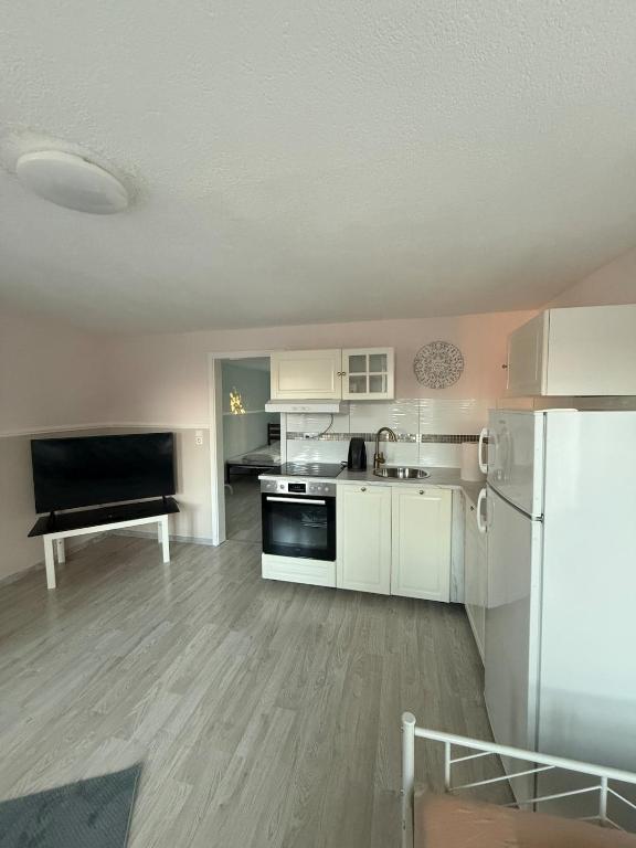 a kitchen with white cabinets and a black appliances at möblierte Ferienwohnung in Günzburg in Ichenhausen