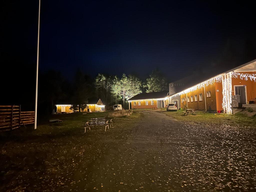a group of buildings lit up at night at Arctic shaman village -Jurtta in Rautuskylä