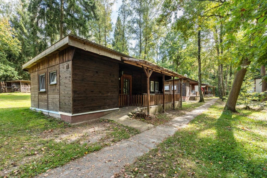 una piccola cabina di legno in un parco con un albero di Bungalow 11 - Finnhütte a Quitzdorf