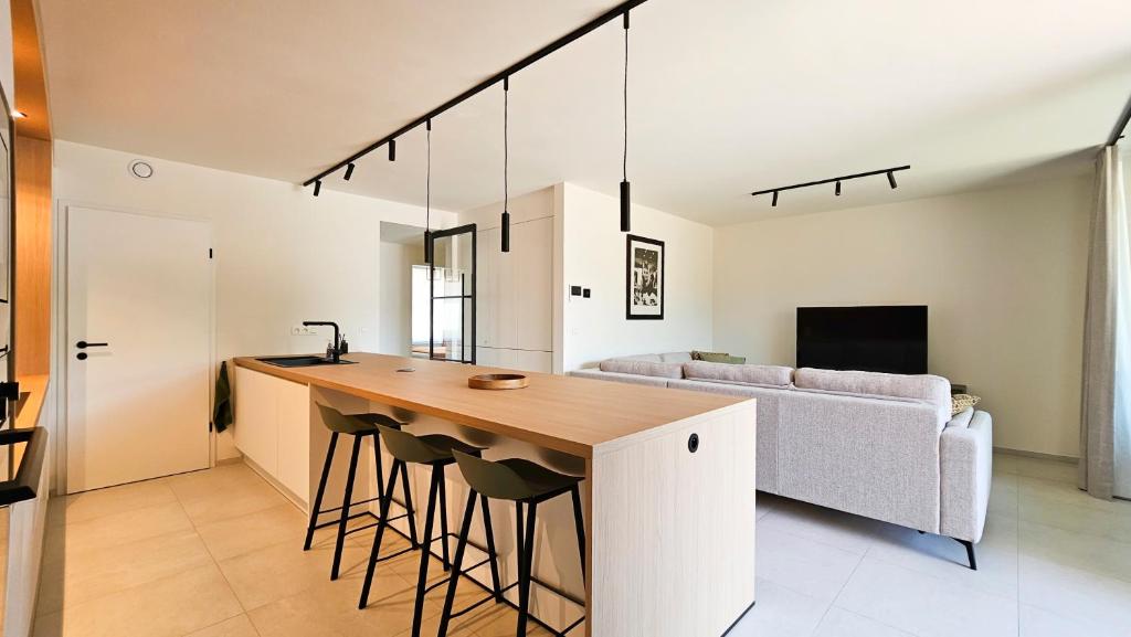 a kitchen and living room with a bar and a couch at Appartement Porte Bonheur in Rochefort