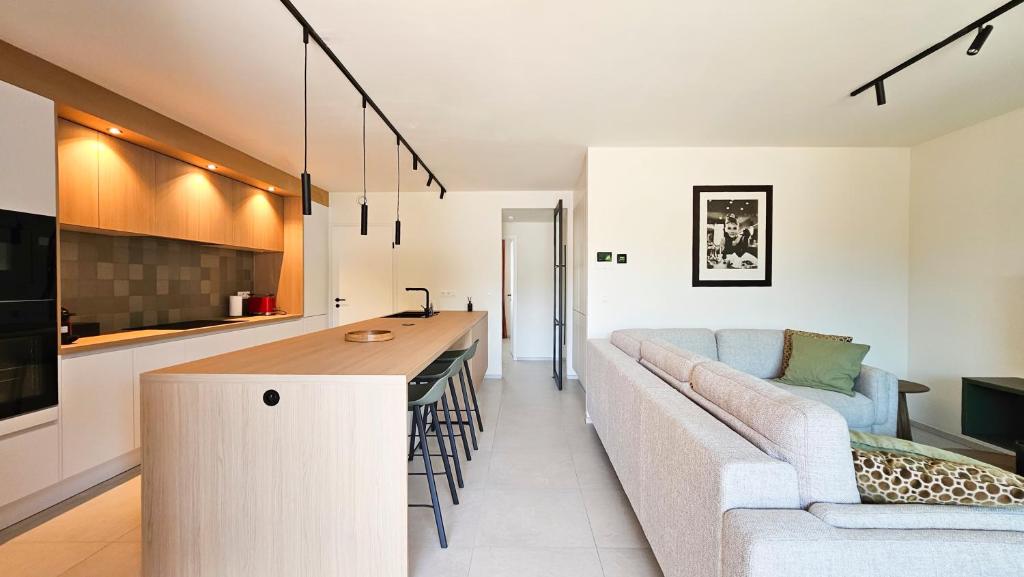 a kitchen and living room with a couch and a table at Appartement Porte Bonheur in Rochefort