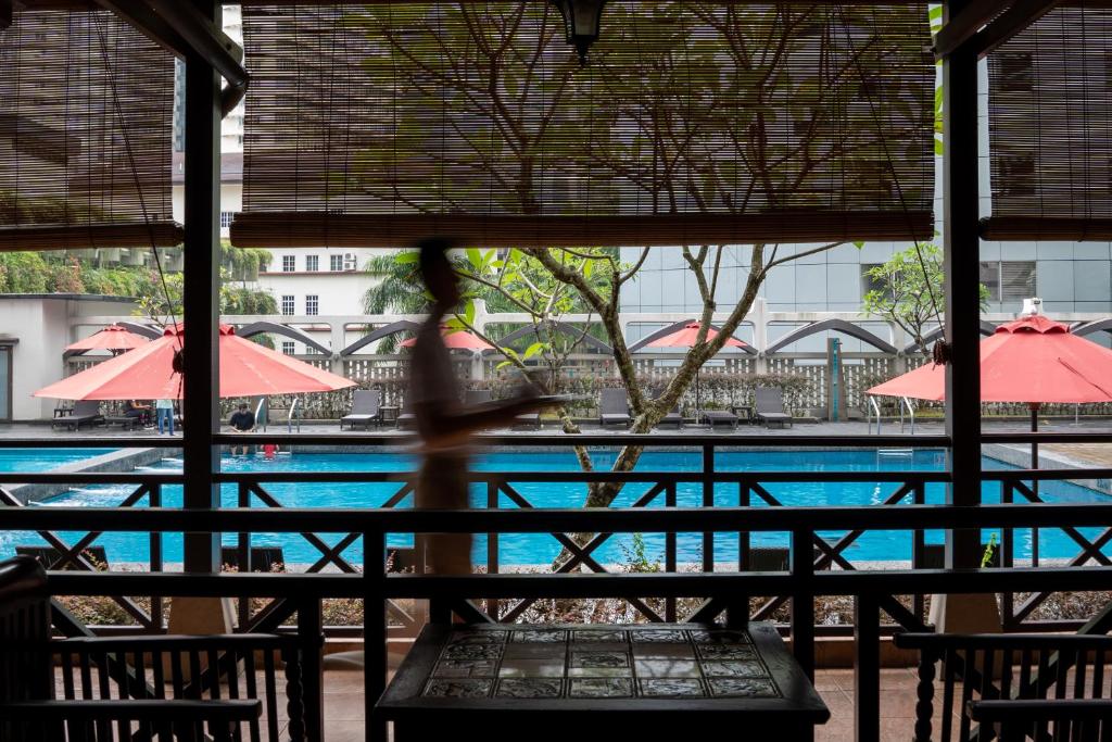 The pool is viewed from a shaded dining or seating area.