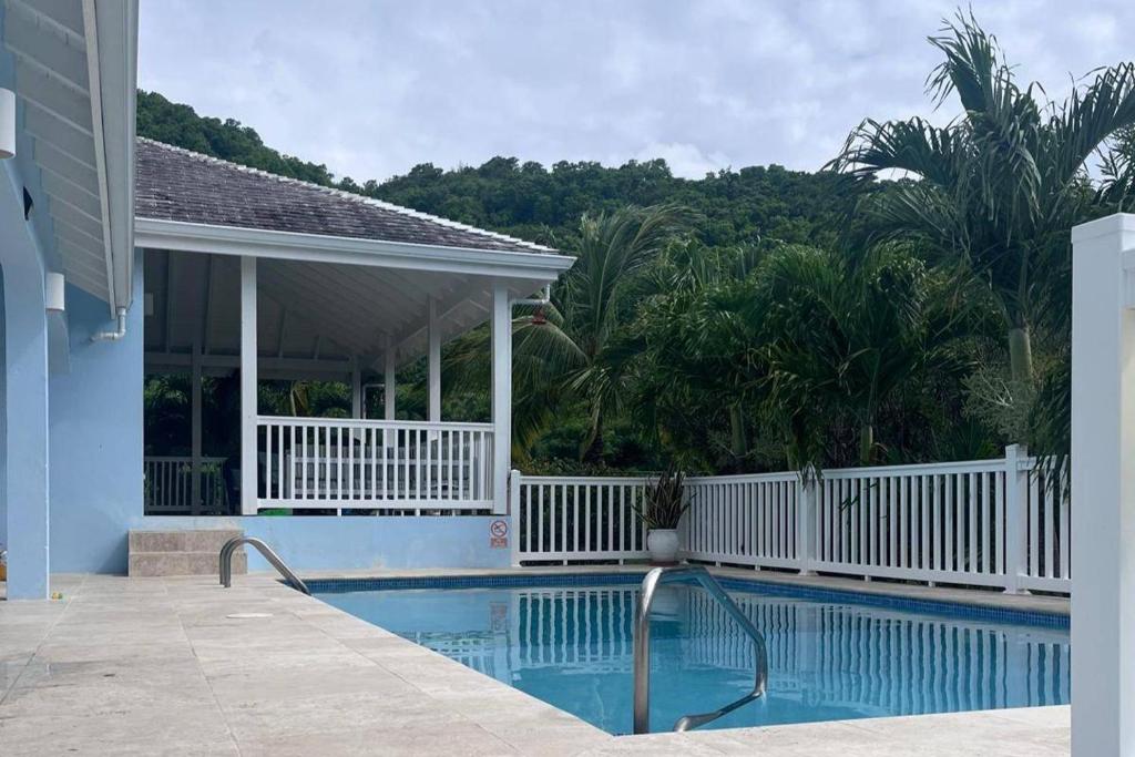 a swimming pool with a gazebo next to a house at Luxury Villa-Sleeps 6-Private Pool in Jolly Harbour
