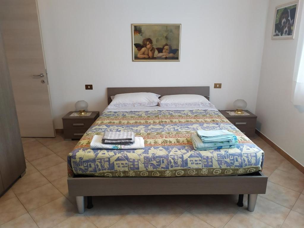 a bed in a bedroom with two night stands and two tables at Da Matte e Ale - Tolmezzo in Tolmezzo