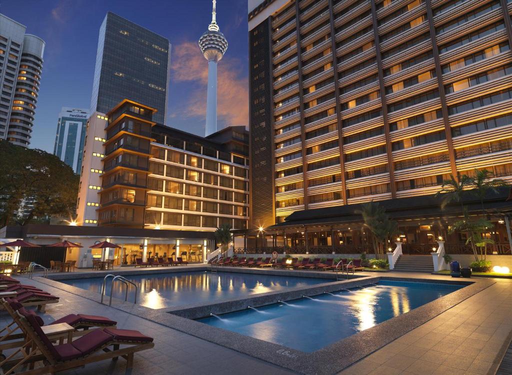 An evening view of the pool terrace pairs illuminated water with Kuala Lumpur’s high-rise skyline.