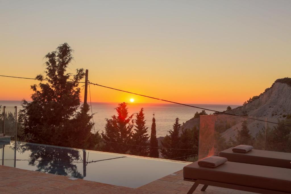 a sunset from a villa with a swimming pool at VV Luxury Villas in Lefkada