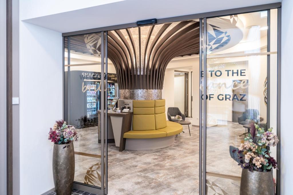 a lobby with a yellow chair and a sign to the top grab at CHRIZZ Rooms in Graz