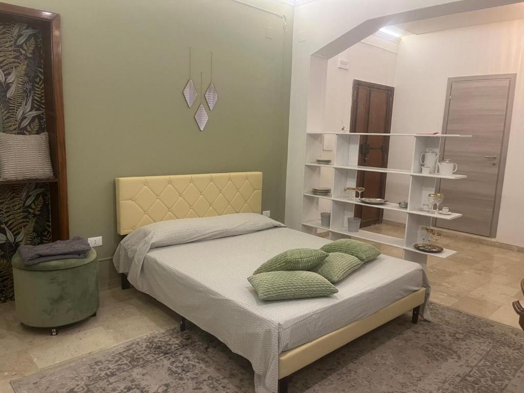 a bedroom with a bed with green pillows on it at B&B Domus Flora in Reggio Calabria