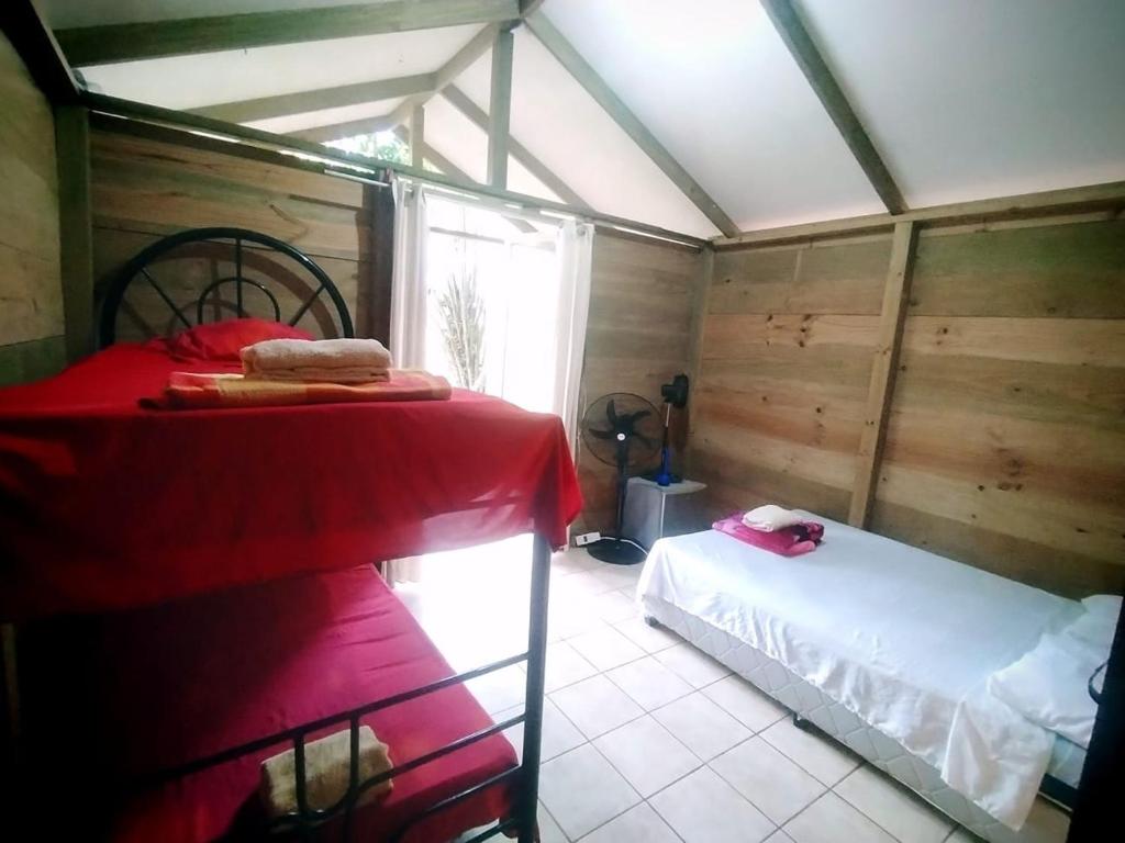 a bedroom with a bed in a room with wooden walls at La Ceiba Biolgical Reserve in Platanillo