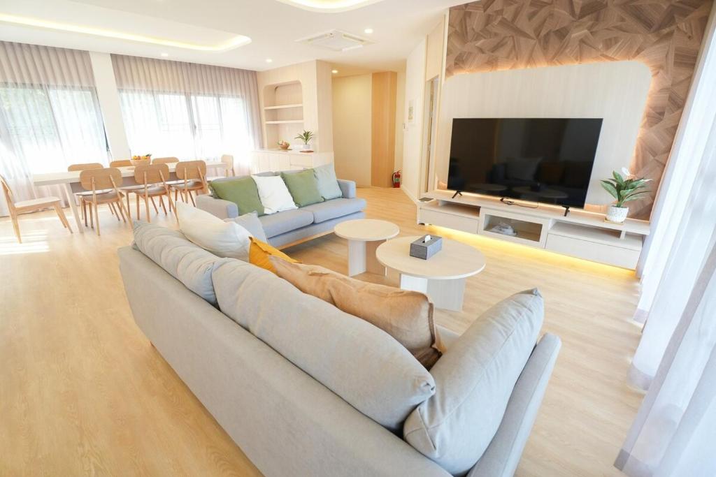 a living room with a couch and a flat screen tv at K5 Seaview Hillside 3BR and 1 Staff Quarter in Ban Ko Kok