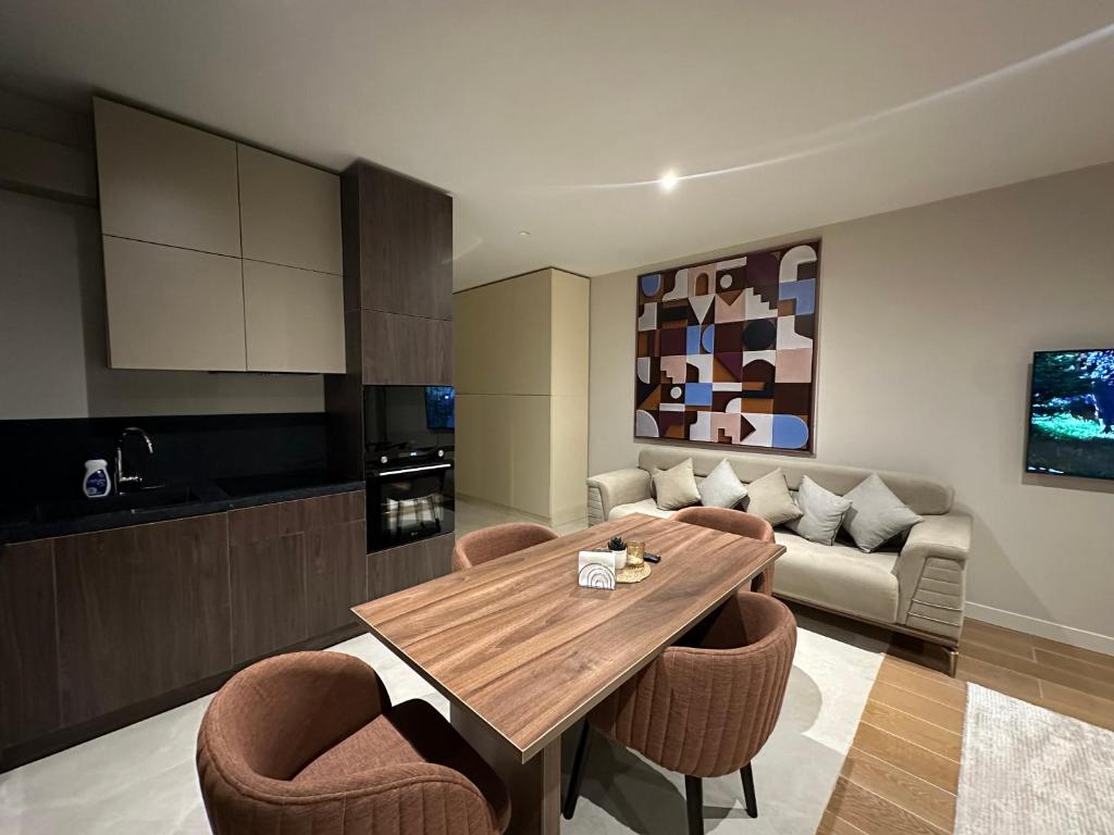 a kitchen and living room with a wooden table and chairs at sea breeze park residences in Mekhrably