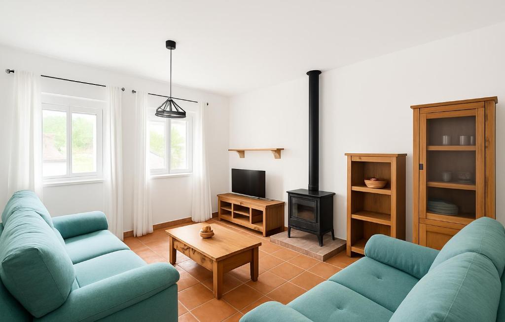 a living room with two blue couches and a tv at Las Palomas in Benamahoma