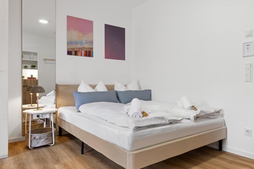a bedroom with a bed with white sheets at BALANCED Münsing Ferienwohnungen Nähe Starnberger See in Münsing am Starnberger See