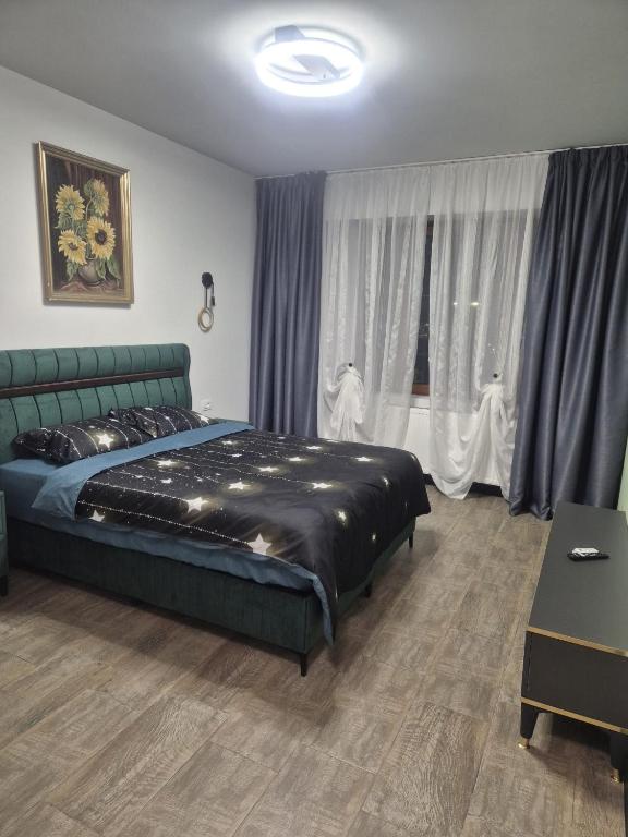 a bedroom with a bed and a window with curtains at Carul cu Flori in Craiova