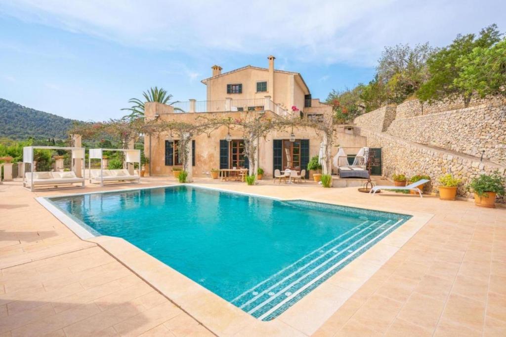 a villa with a swimming pool in front of a house at Majestic Holiday Estate in Calvià Up to 12 Guests in Calvia Town