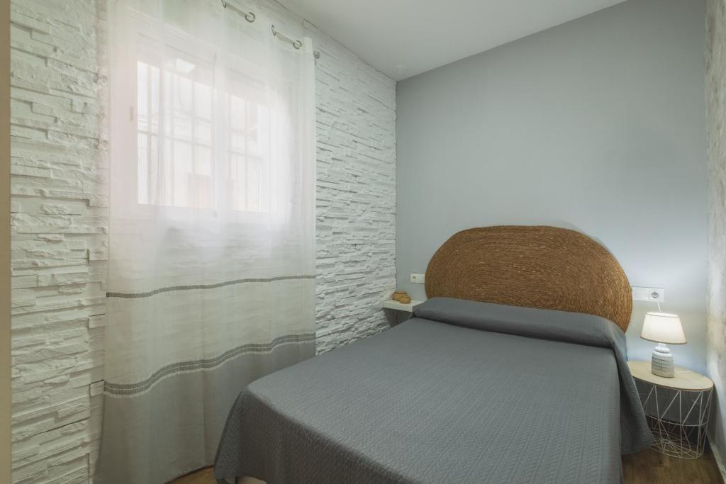 a bedroom with a bed and a window at Geminis in Rota