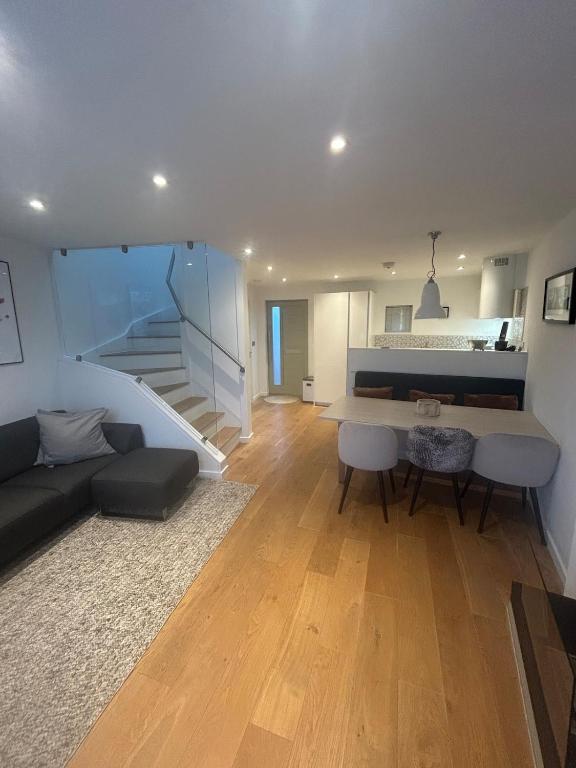 a living room with a table and a couch and a staircase at Escape to Infinity! in Guernsey