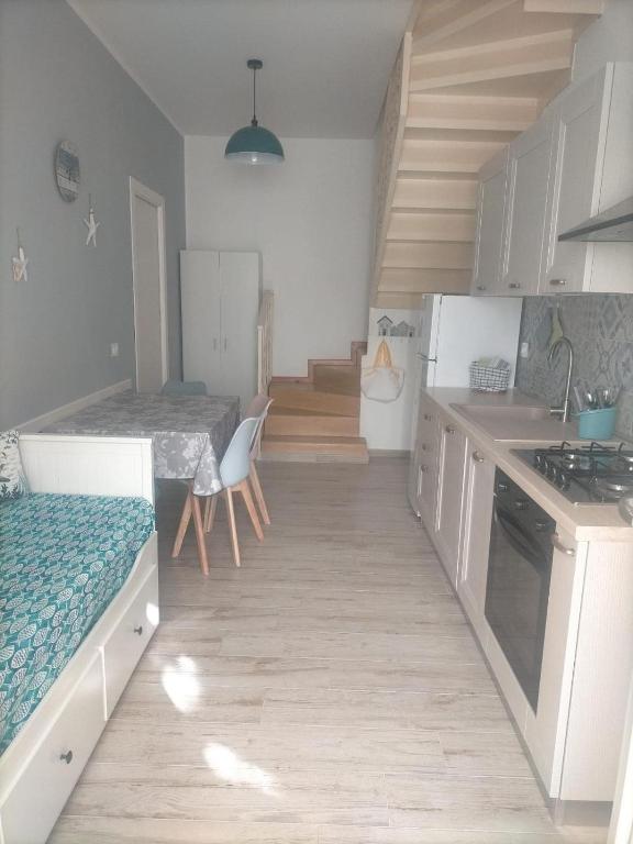 a kitchen with white cabinets and a wooden floor at Da BeA in Villasimius