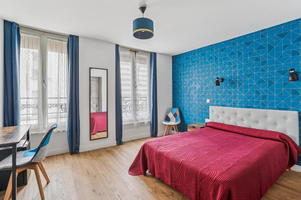 niebieska sypialnia z łóżkiem, stołem i krzesłami w obiekcie Hotel Telemaque w Paryżu