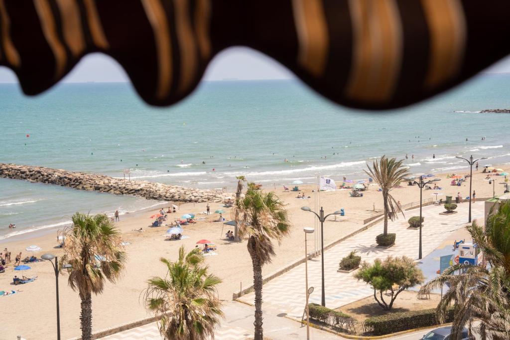 una vista di una spiaggia con palme e l'oceano di Ático con vistas a Port Saplaya