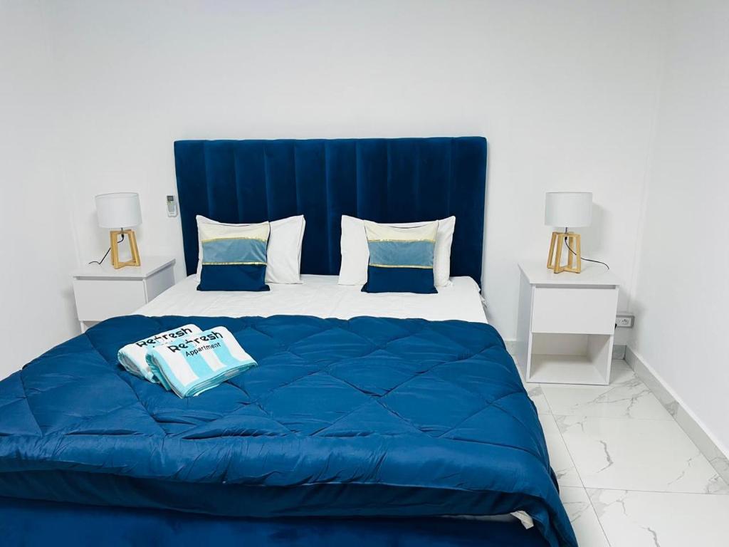 a blue bed with a blue comforter and pillows at Refresh Holidays in Mont Choisy