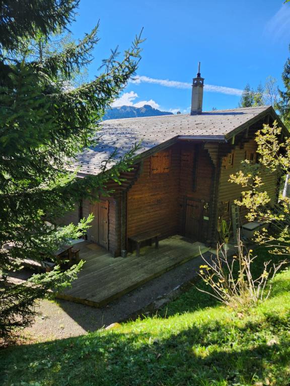 Cabaña de madera con terraza de madera en el patio en Le Banhaut, en Les Diablerets