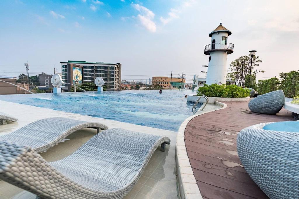 a swimming pool with a lighthouse on a building at Supalai Mare Pattaya & City Center in Pattaya South