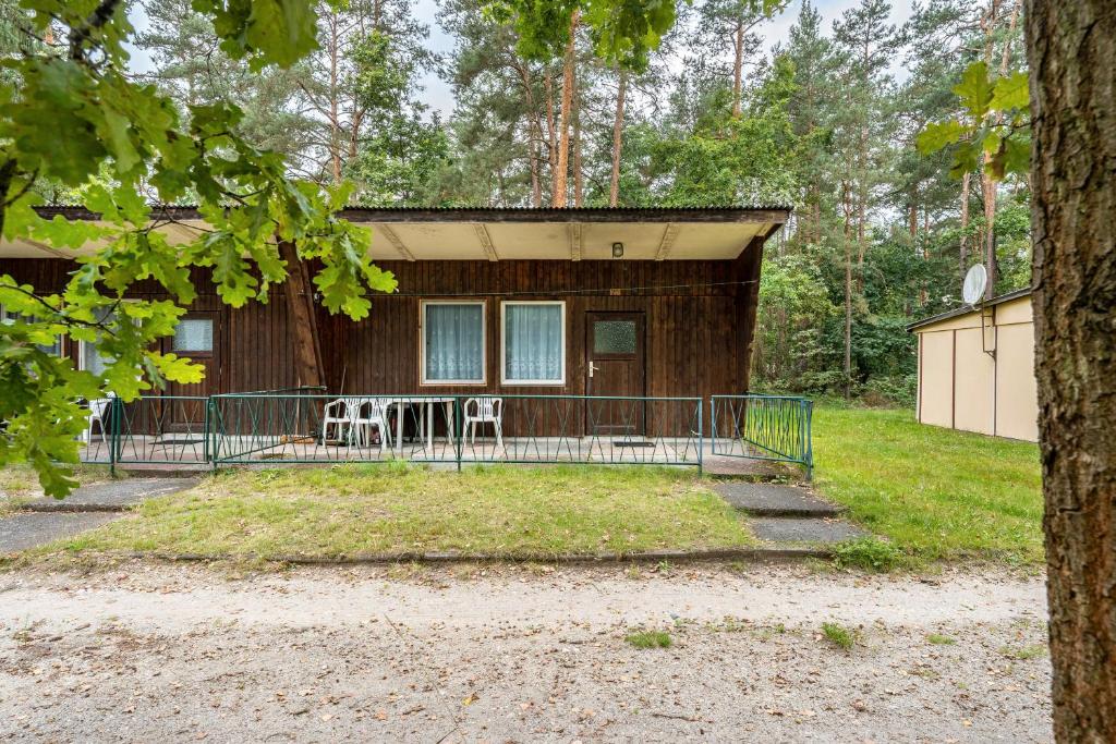a house with a porch with two chairs in front of it at Bungalow 20 - Kimbucht in Reichendorf