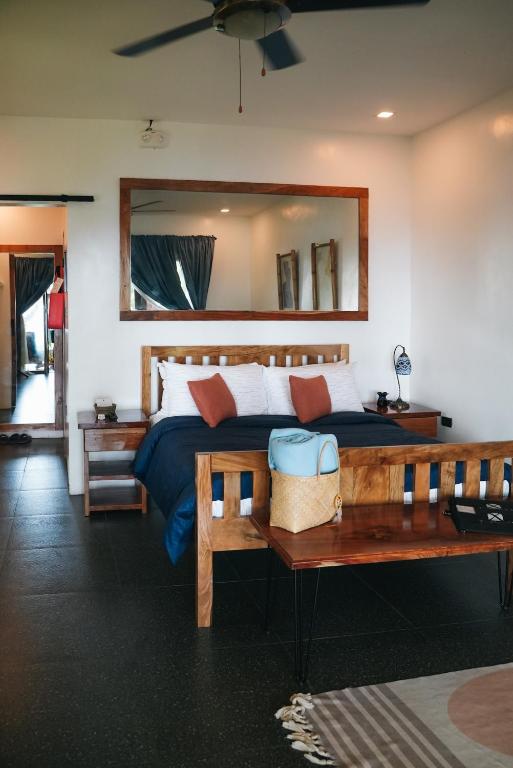 曼巴豪Txaleta de Camiguin desde 2024的一间卧室配有一张带镜子和长凳的床