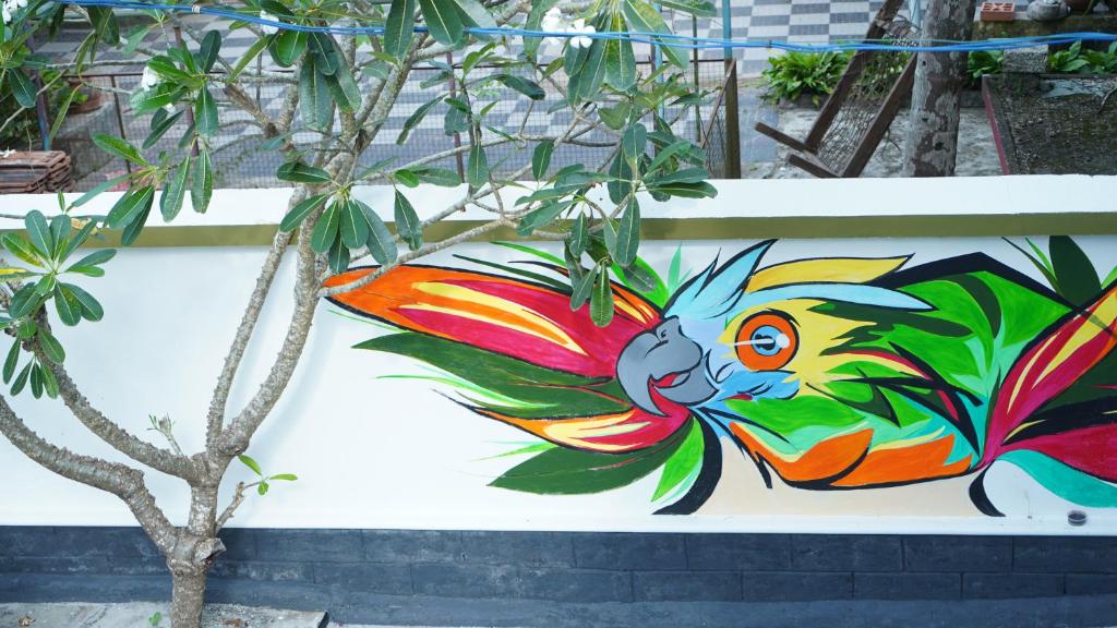 Una pintura de un pájaro colorido en una pared. en Avaiaa, en Varkala