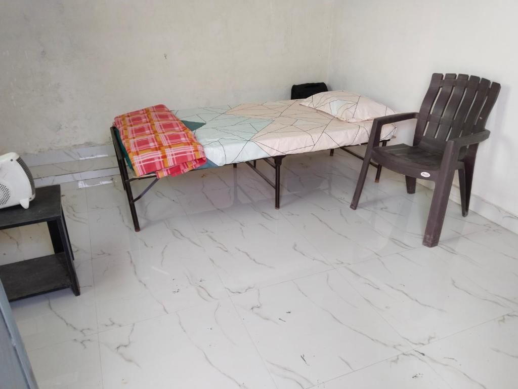a small bed and a chair in a room at Omkar Homestay in Prayagraj