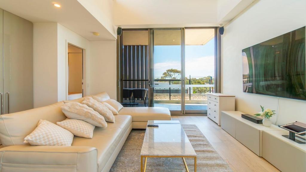 シドニーにあるLeafy Retreat Spacious 2B Penthouse 1 Parkingのソファとテーブルのあるリビングルーム
