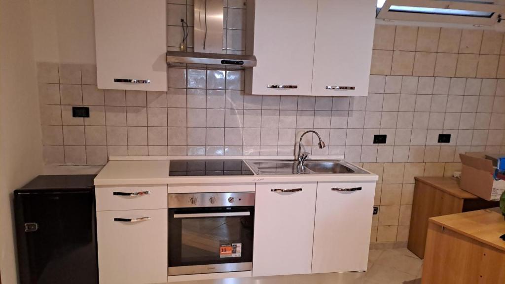 Una cocina con gabinetes blancos y un fregadero. en Dj Center Class, en Bari