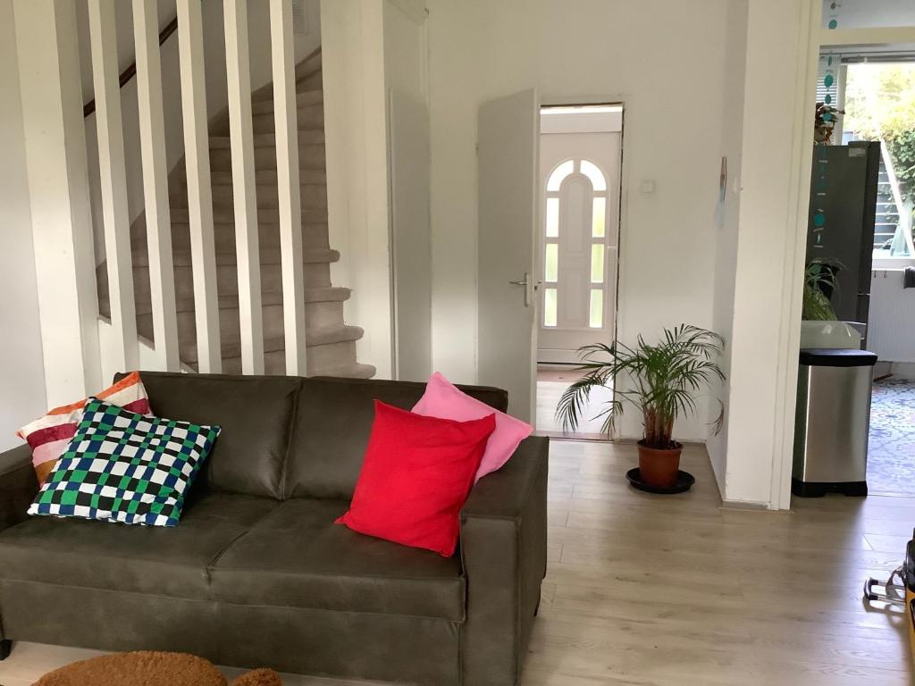 a living room with a brown couch with colorful pillows at Cricri in Lelystad