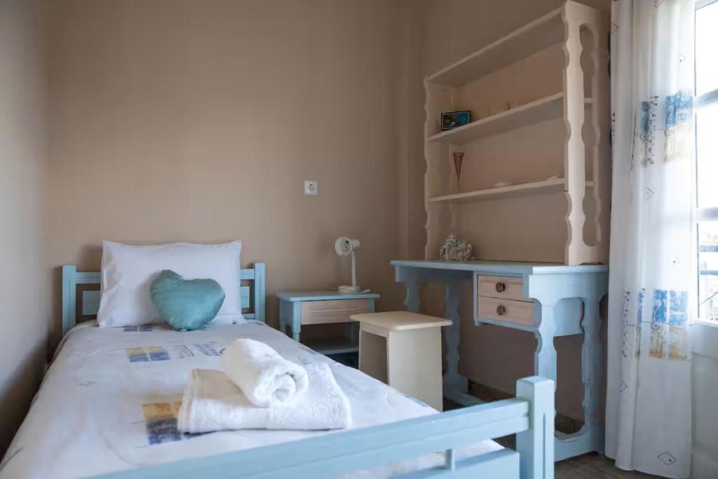 a bedroom with a bed with towels on it at Dimitra's Little House in Petalidhion
