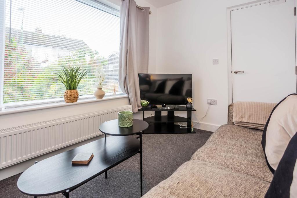 a living room with a couch and a table and a tv at Monks Crescent in Gilesgate