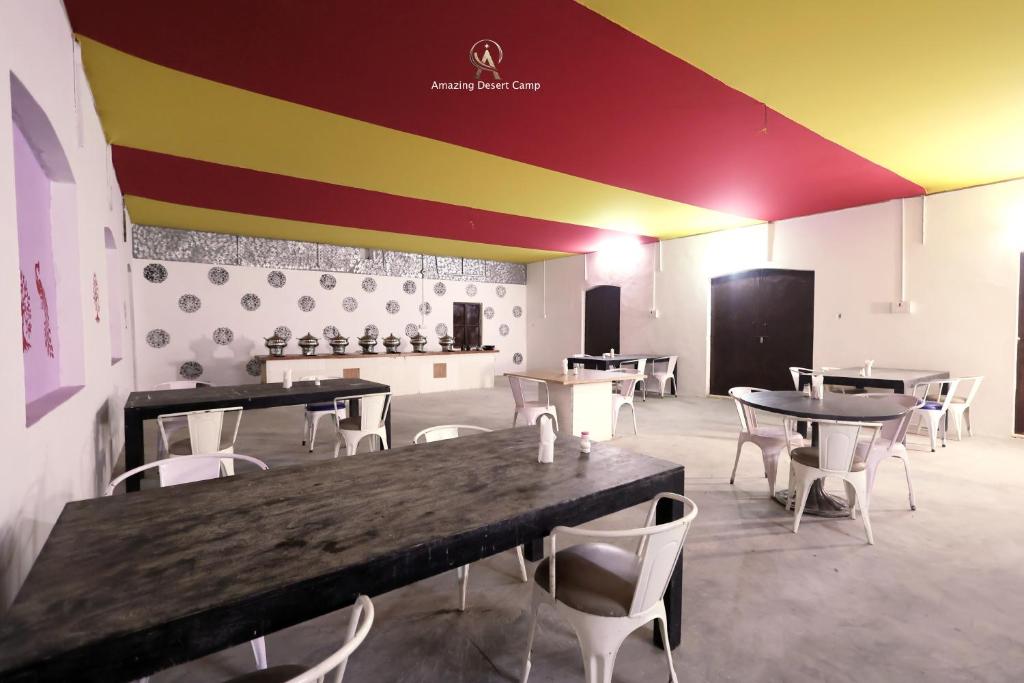 Un restaurante con mesas y sillas en una habitación. en Amazing Desert Camp, en Jaisalmer
