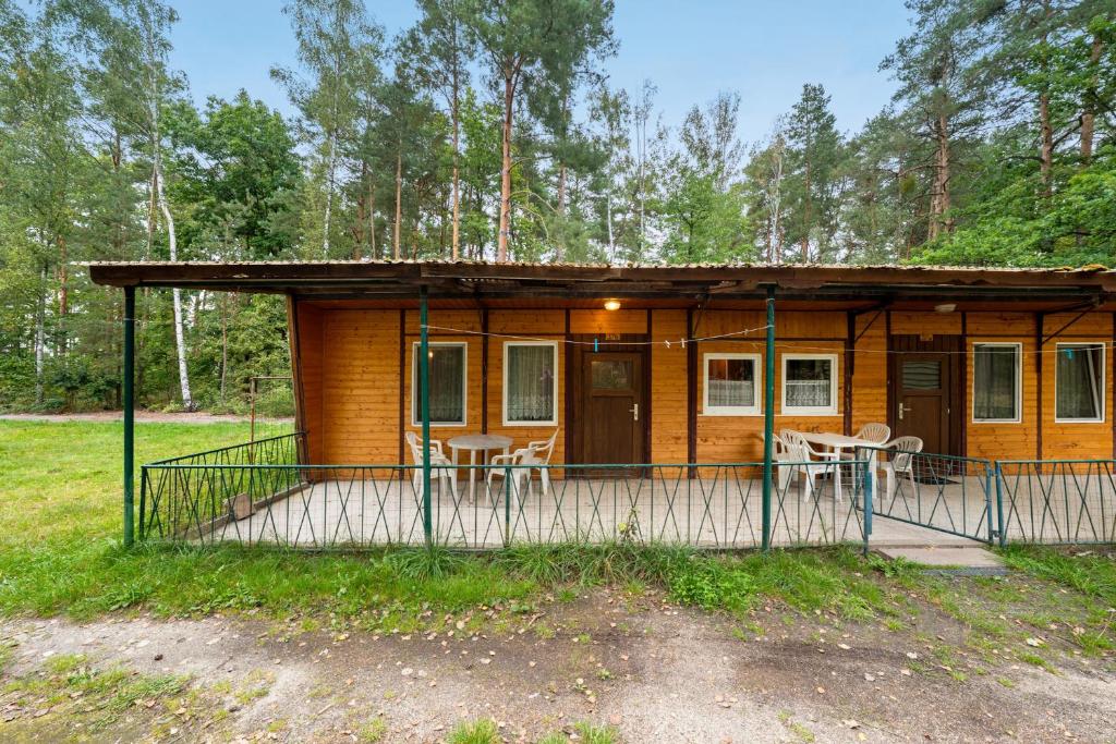 a cabin in the woods with a porch and chairs at Bungalow 37b - Kimbucht in Reichendorf