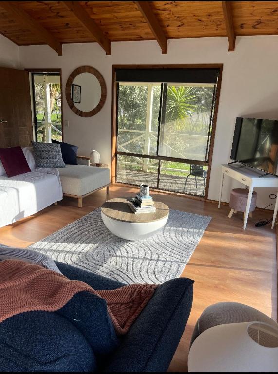 a living room with a couch and a table at Happy Valley Haven in Sunset Strip