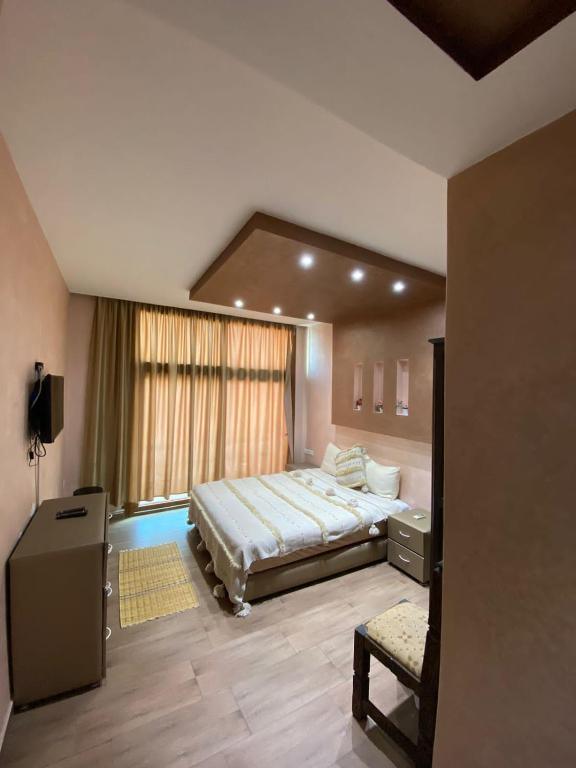 a bedroom with a large bed and a window at Nomad Hotel Tamraghet in Aourir