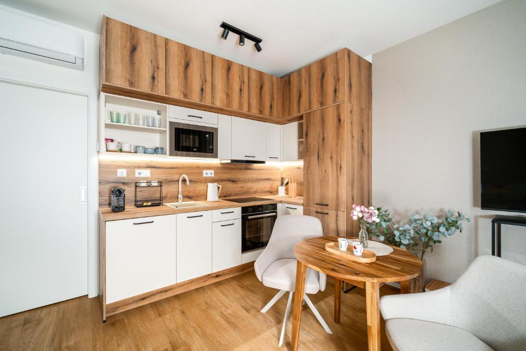 a kitchen with white cabinets and a table with chairs at Apartmán Klement A in Znojmo