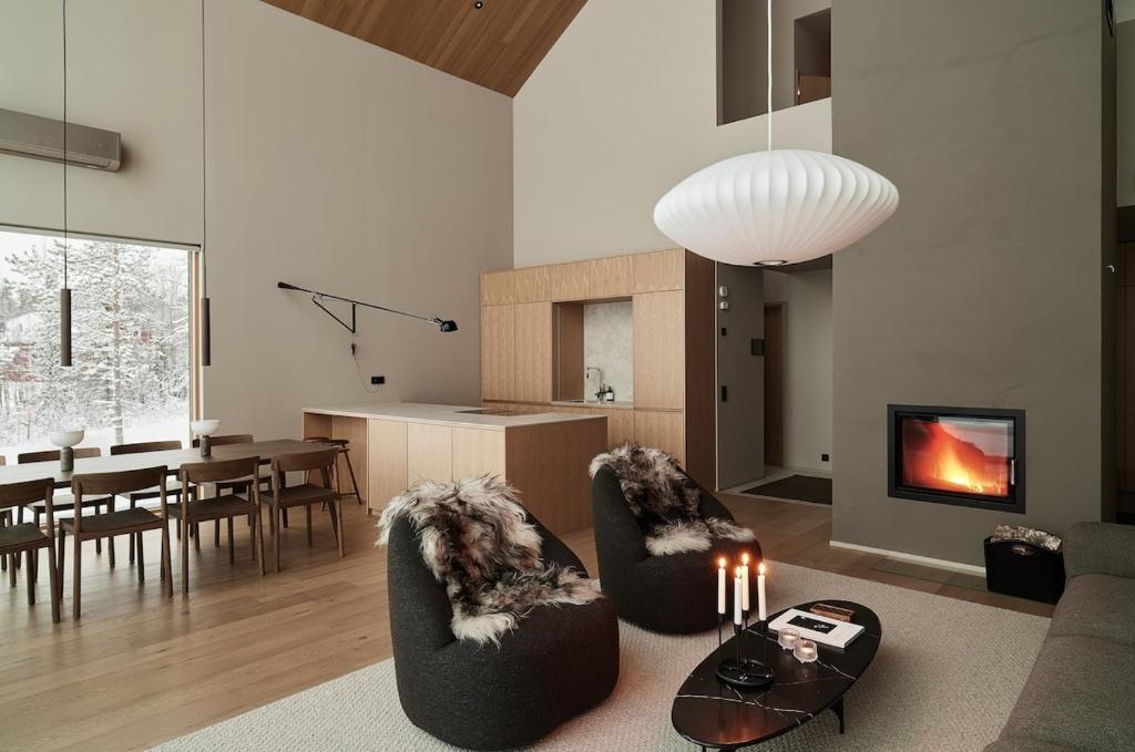 a living room with a couch and chairs and a table at Joiku Luxury Lakeview Chalet in Kolari