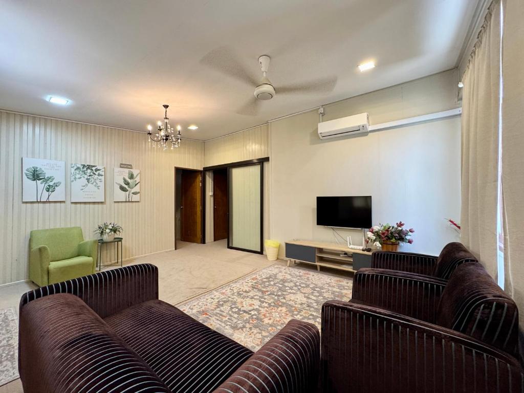 a living room with two couches and a flat screen tv at Sarah Guesthouse in Kuala Terengganu