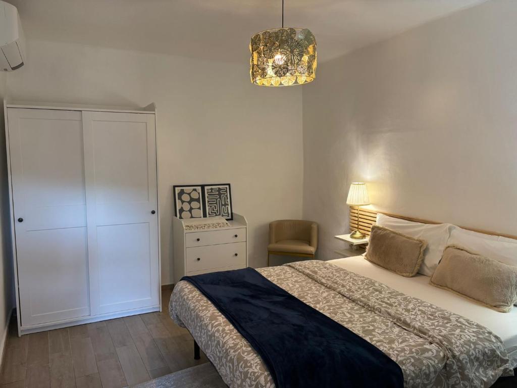 a bedroom with a bed and a cabinet and a chandelier at Casa Eva in Dolceacqua