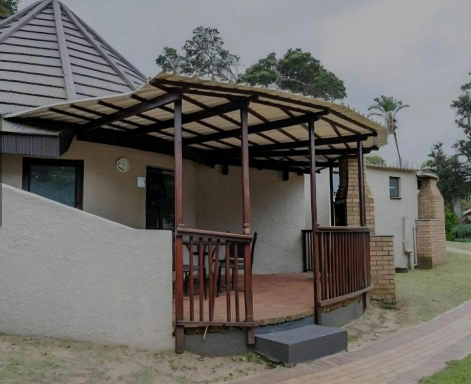 a wooden pergola on a porch of a house at Banana Beach Club C5 in Port Shepstone