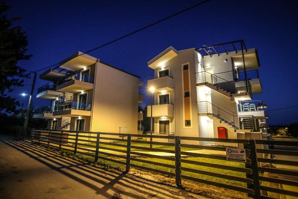 a large building with a fence in front of it at Amphipolis Deluxe Apartments in Ofrínion