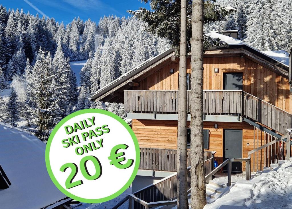 Un cartel delante de una cabaña de troncos en la nieve. en Apartment MOUNTAIN PEARL Golte, en Mozirje